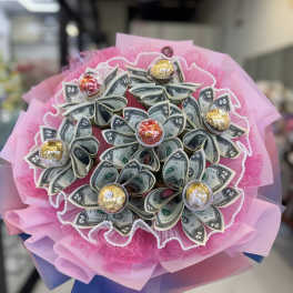 Bouquet made of folded dollar bills with pink wrapping and candy accents