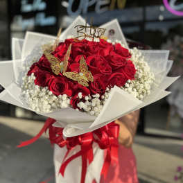 Red rose bouquet with baby’s breath, butterfly picks, and a birthday topper