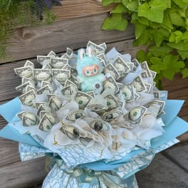Bouquet of folded dollar bills with a small plush bunny topper