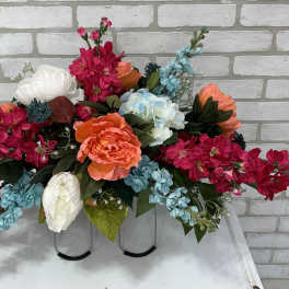 Bright mixed floral arrangement with pink, blue, white, and orange blooms