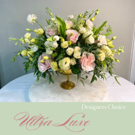 Pastel rose and lisianthus arrangement in a gold pedestal vase