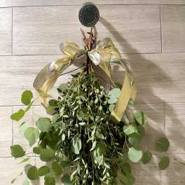 Hanging bundle of green eucalyptus tied with a gold ribbon