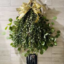 Hanging greenery arrangement with a gold ribbon bow