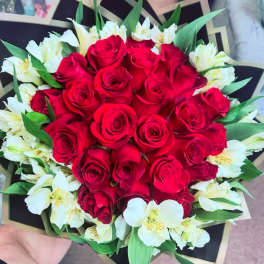 Bouquet of red roses and white alstroemeria with green leaves