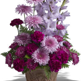 Lavender and magenta flowers arranged in an ornate pot