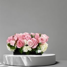 Pink and white rose arrangement in a black rectangular container