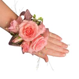 Pink rose wrist corsage with ribbon and small decorative accents