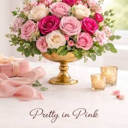 Pink and cream roses arranged in a gold pedestal vase