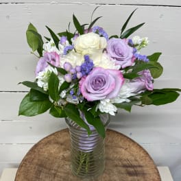 Lavender and white rose bouquet in a clear glass vase