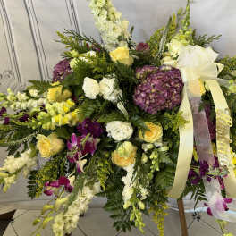 Large standing floral spray with yellow, white, purple, and pink blooms