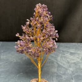 Gold wire gemstone tree sculpture with purple crystal chips on a stone base