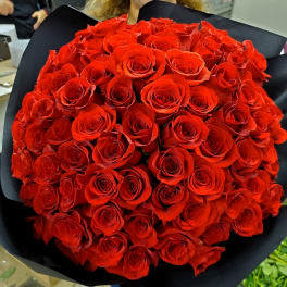 Large bouquet of red roses wrapped in black paper