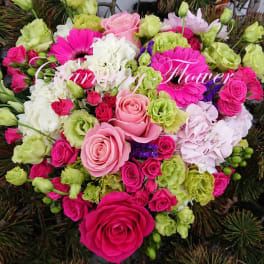 Heart-shaped bouquet of pink, white, and green flowers