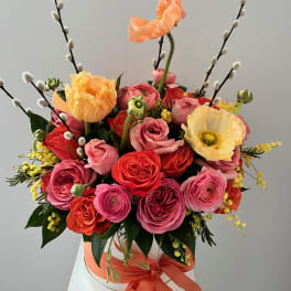 Bouquet of pink and orange roses with poppies in a white hat box