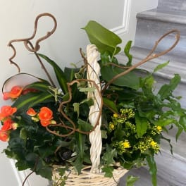 Basket arrangement with orange roses and yellow flowers