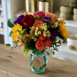 Colorful mixed bouquet in a turquoise glass vase