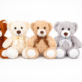 Four plush teddy bears with bows on a white background