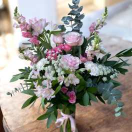 Pink and white bouquet in a clear glass vase with eucalyptus