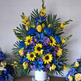 Blue, yellow, and purple floral arrangement in a white vase