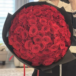 Large bouquet of red roses wrapped in black paper