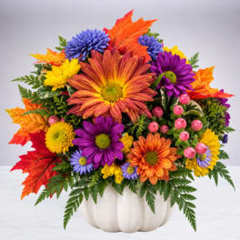 Colorful autumn bouquet in a white pumpkin-shaped container