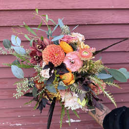 Hand-tied bouquet of pink, orange, and burgundy flowers