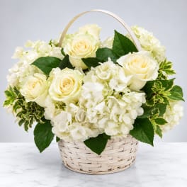 White roses and hydrangeas in a woven basket