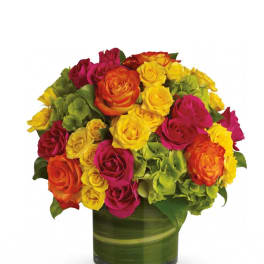 Bright mixed rose bouquet in a green glass vase