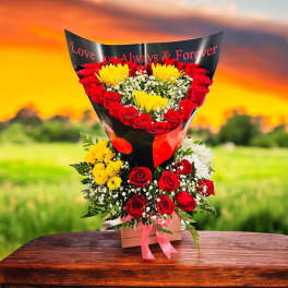 Heart-shaped bouquet of red roses and yellow flowers in black wrap