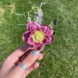 Handheld pink and white flower boutonniere with purple accents