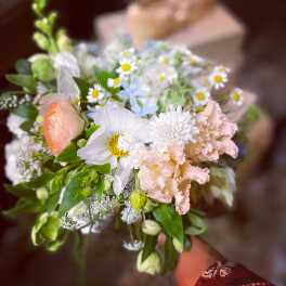 Pastel bouquet with white daisies, peach blooms, and pink ruffled flowers