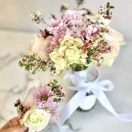 Two small floral bouquets with pale roses and pink daisies