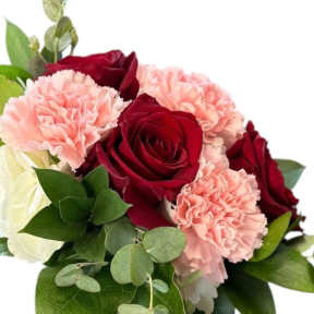 Bouquet of red roses and pink carnations with greenery