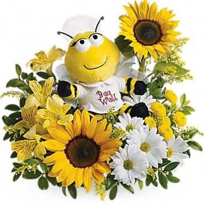 Cheerful arrangement of sunflowers and white daisies with a plush bee toy in the center