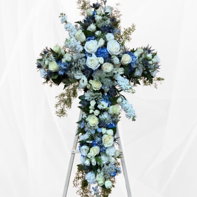 Large blue and white floral cross arrangement on a stand
