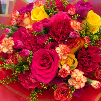 Bouquet of pink, red, and yellow roses with carnations