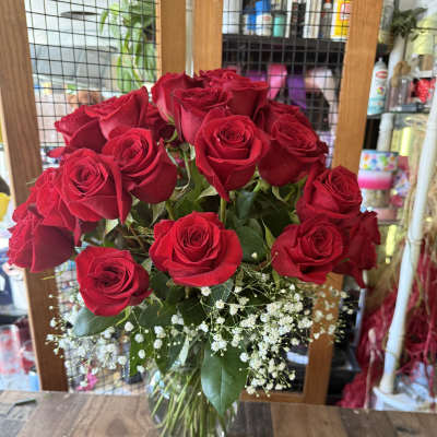 Red roses in a clear glass vase with white baby's breath