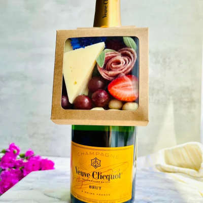 Champagne bottle with a fruit-and-cheese gift box attached