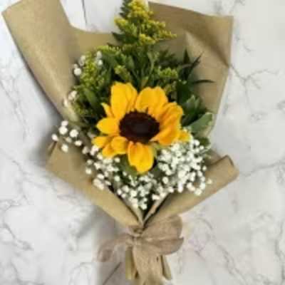 Sunflower bouquet wrapped in brown paper with white filler flowers