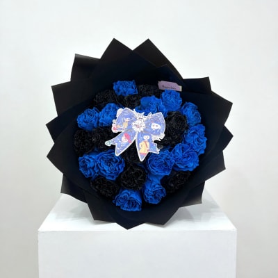 Blue and black rose bouquet wrapped in black paper with a decorative topper