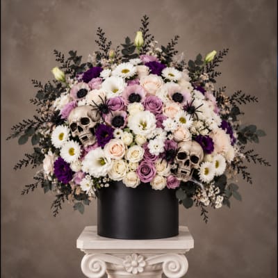 Large floral arrangement in a black box with two skull decorations
