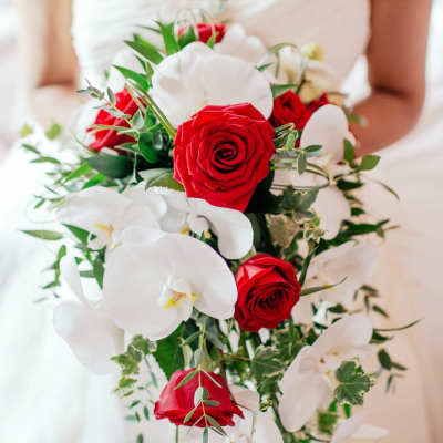 Bride holding a bouquet of red roses and white orchids