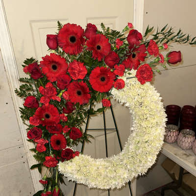 Heart-shaped floral wreath with red roses, gerbera daisies, and white chrysanthemums