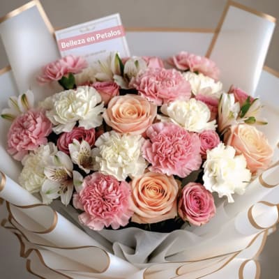 Pink and white bouquet of roses and carnations wrapped in white paper