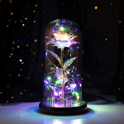 Glowing artificial flower under a glass dome with multicolor lights