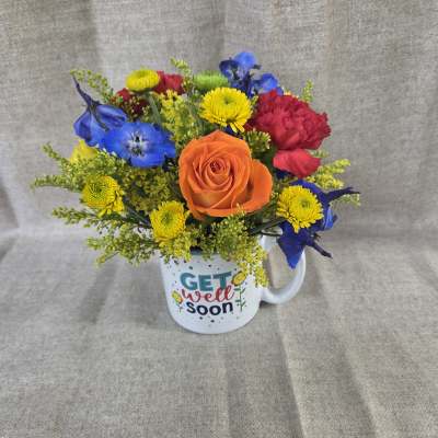 Colorful mixed bouquet in a white mug with a get well soon message