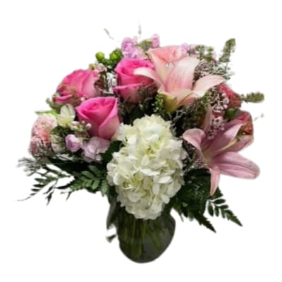 Pink roses and lilies with white hydrangea in a glass vase