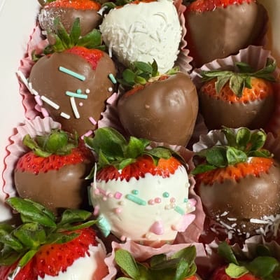 Box of chocolate-covered strawberries with sprinkles and coconut flakes
