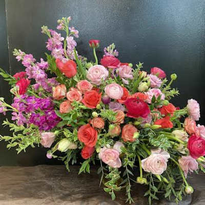 Large mixed bouquet of pink and coral flowers with greenery