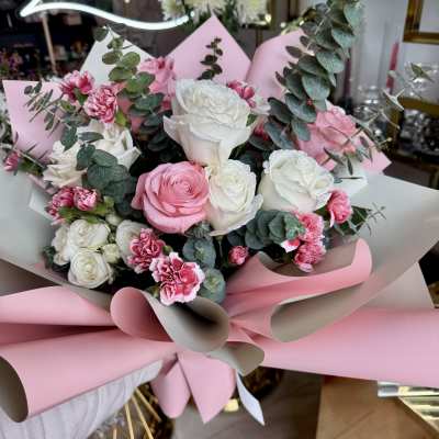 Pink and white rose bouquet with carnations and eucalyptus wrapping